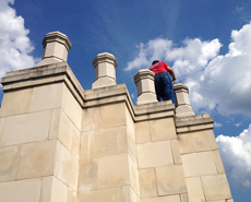 a man in a red shirt is standing on top of a building