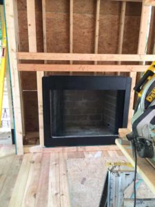 a fireplace is being built in a house and a circular saw is sitting next to it .