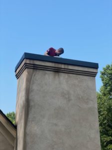 a man is standing on top of a chimney .